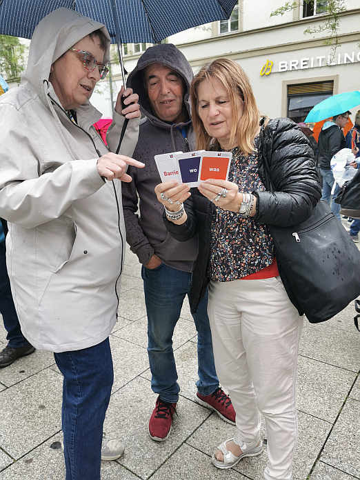 Spielerisch Barrieren abbauen: Gut beschützt vor dem Regen werden die „Karten für Inklusion“ in der Stuttgarter Innenstadt mit Passanten getestet.<br>Foto: © Beate Gärtner